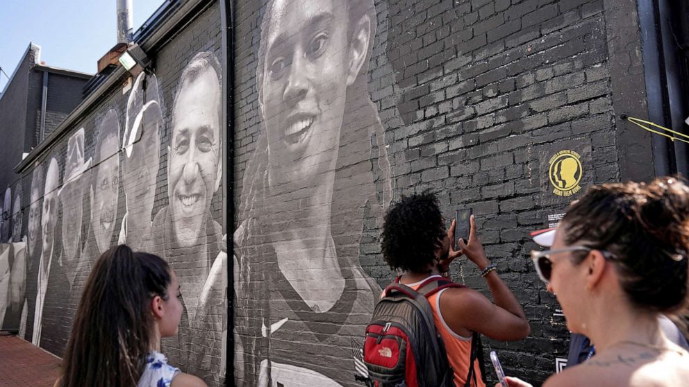 PHOTO: People visit a mural depicting photos of American hostages around the world, created by the Bring Our Families Home Campaign, is seen in the Georgetown neighborhood of Washington, D.C., July 20, 2022.