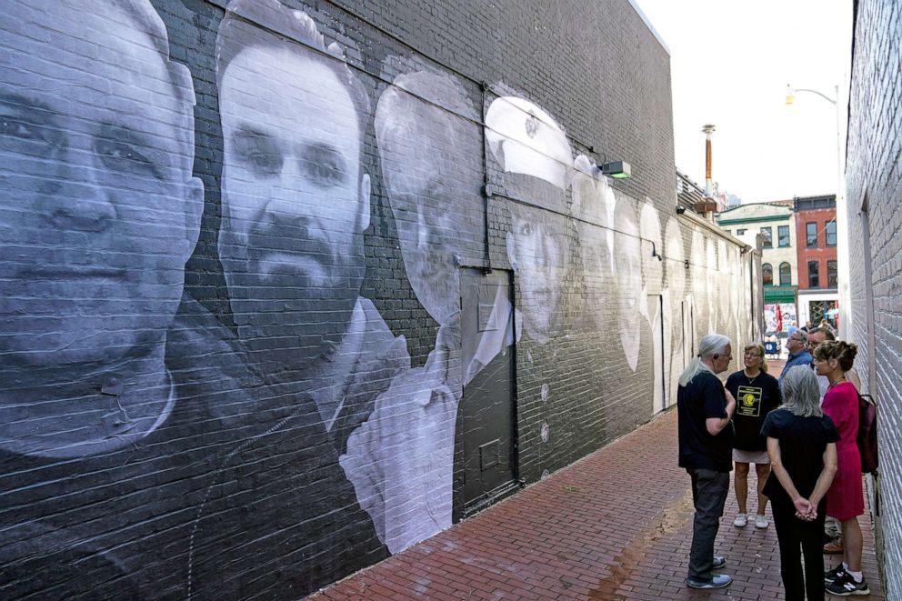 PHOTO: People visit a mural depicting photos of American hostages around the world, created by the Bring Our Families Home Campaign, is seen in the Georgetown neighborhood of Washington, D.C., July 20, 2022.