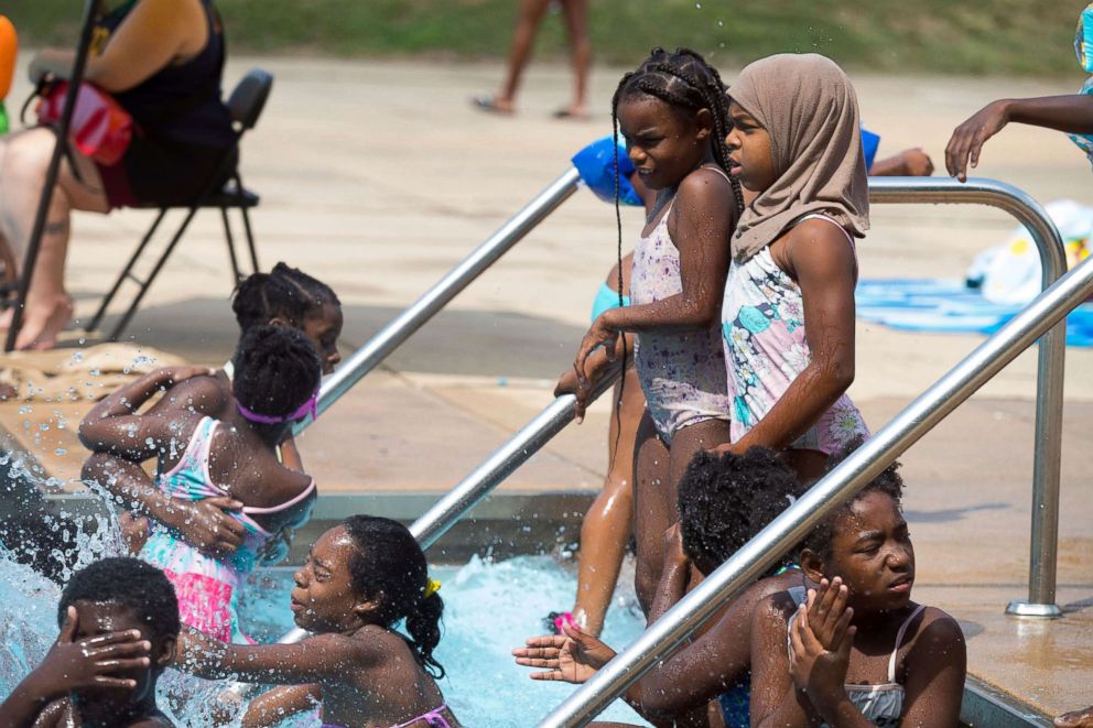 PHOTO: Auliyn Brown, right, enters the water at Dr. Foster M. Brown Pool, July 12, 2018 in Wilmington, Del.