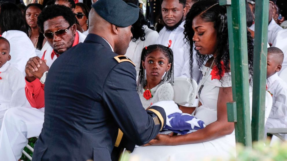 PHOTO: Myeshia Johnson is presented with a folded U.S. flag by a military honor guard member during the burial service for her husband U.S. Army Sgt. La David Johnson at the Memorial Gardens East cemetery, Oct. 21, 2017, in Hollywood, Fla.

