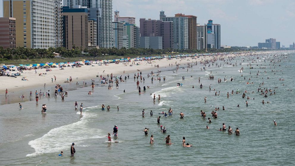 PHOTO: People wade in the ocean on July 4, 2020, in Myrtle Beach, S.C.