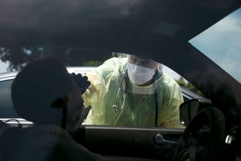 PHOTO: Physician assistant Nicole Kramer collects a nasal swab sample from a patient for COVID-19 testing in Tustin, California, on June 25, 2020.