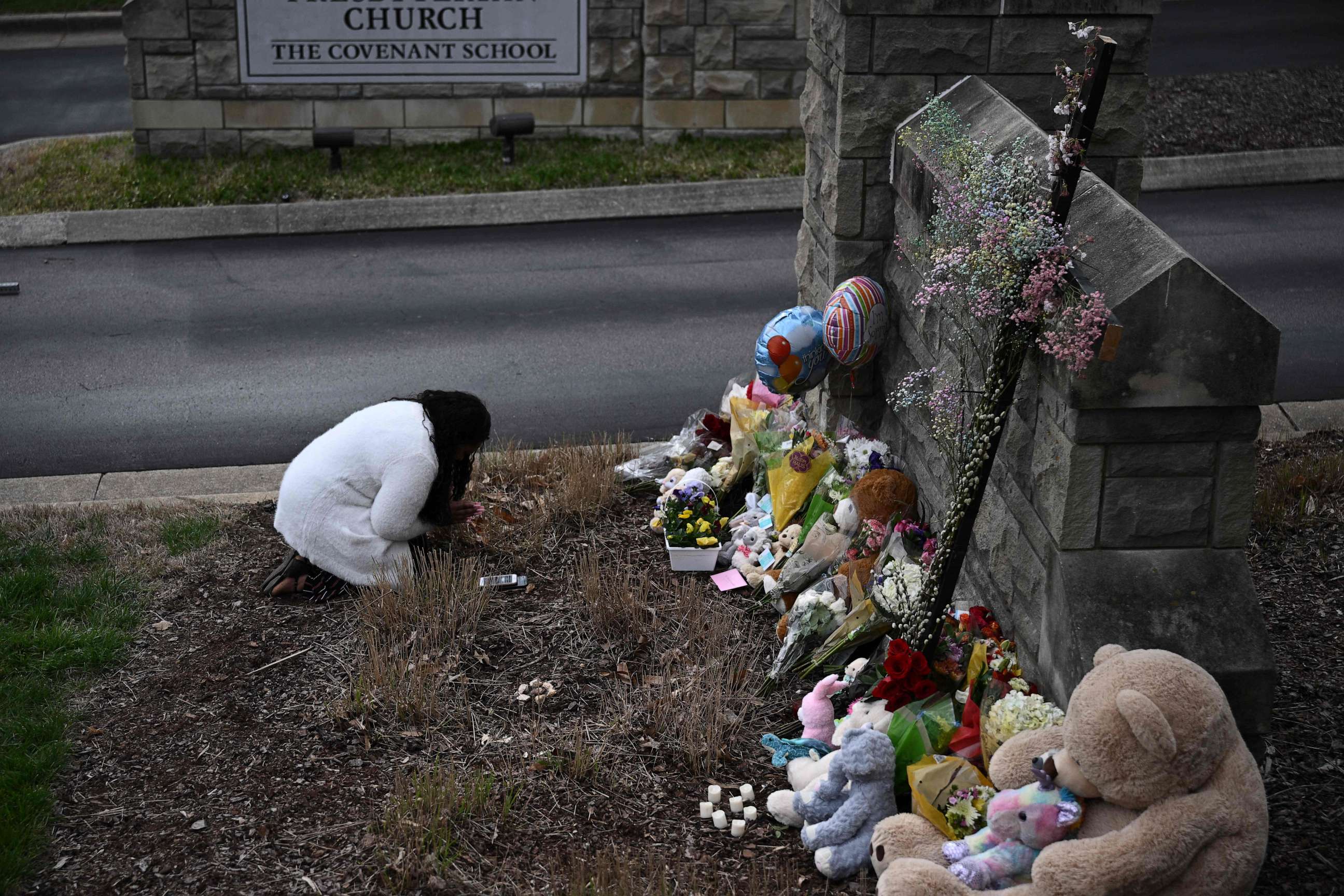 PHOTO: A woman pays her respects at a makeshift memorial for shooting victims outside the Covenant School building at the Covenant Presbyterian Church in Nashville, Tenn., March 28, 2023.