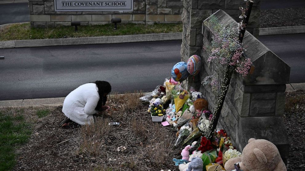 PHOTO: A woman pays her respects at a makeshift memorial for shooting victims outside the Covenant School building at the Covenant Presbyterian Church in Nashville, Tenn., March 28, 2023.