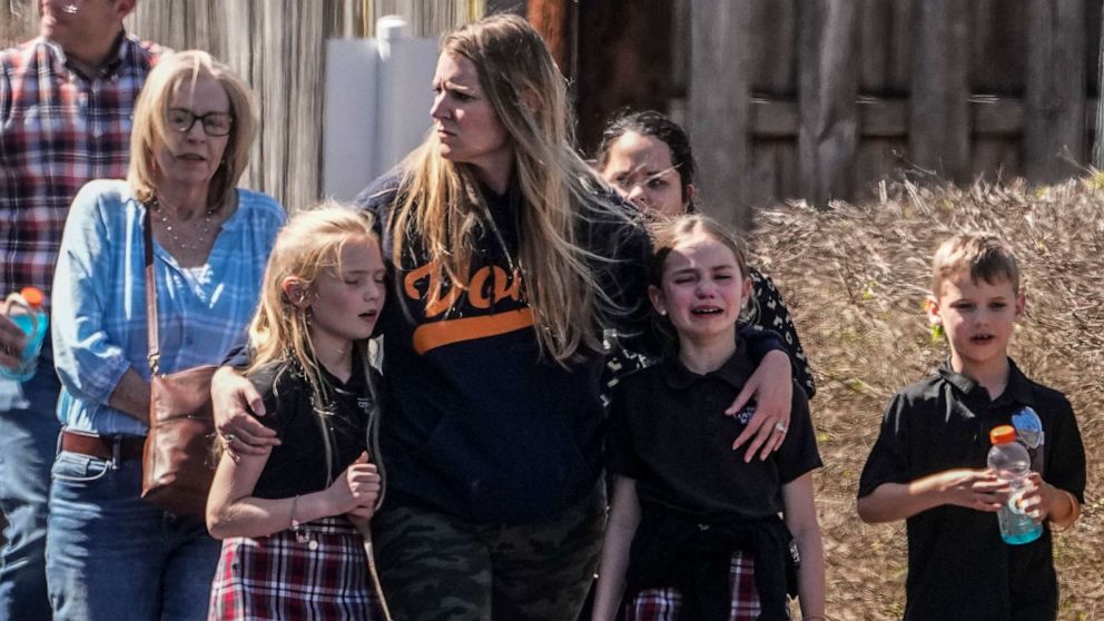 PHOTO: Children and a woman depart the reunification center at the Woodmont Baptist church after a school shooting, Mar. 27, 2023, in Nashville, Tenn.