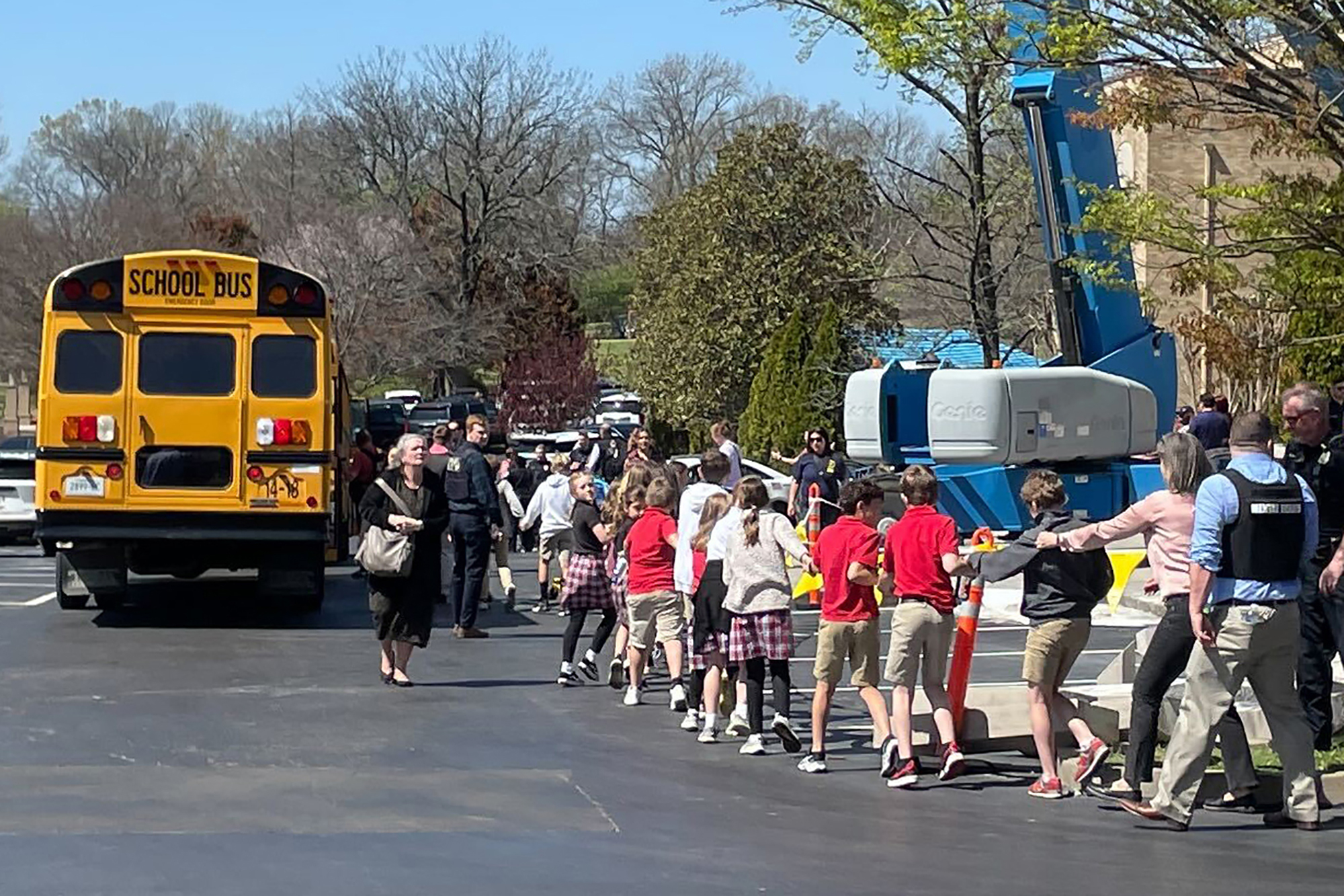 PHOTO: Children from The Covenant School, a private Christian school in Nashville, Tenn., hold hands as they are taken to a reunification site after a deadly shooting at their school, March 27, 2023.