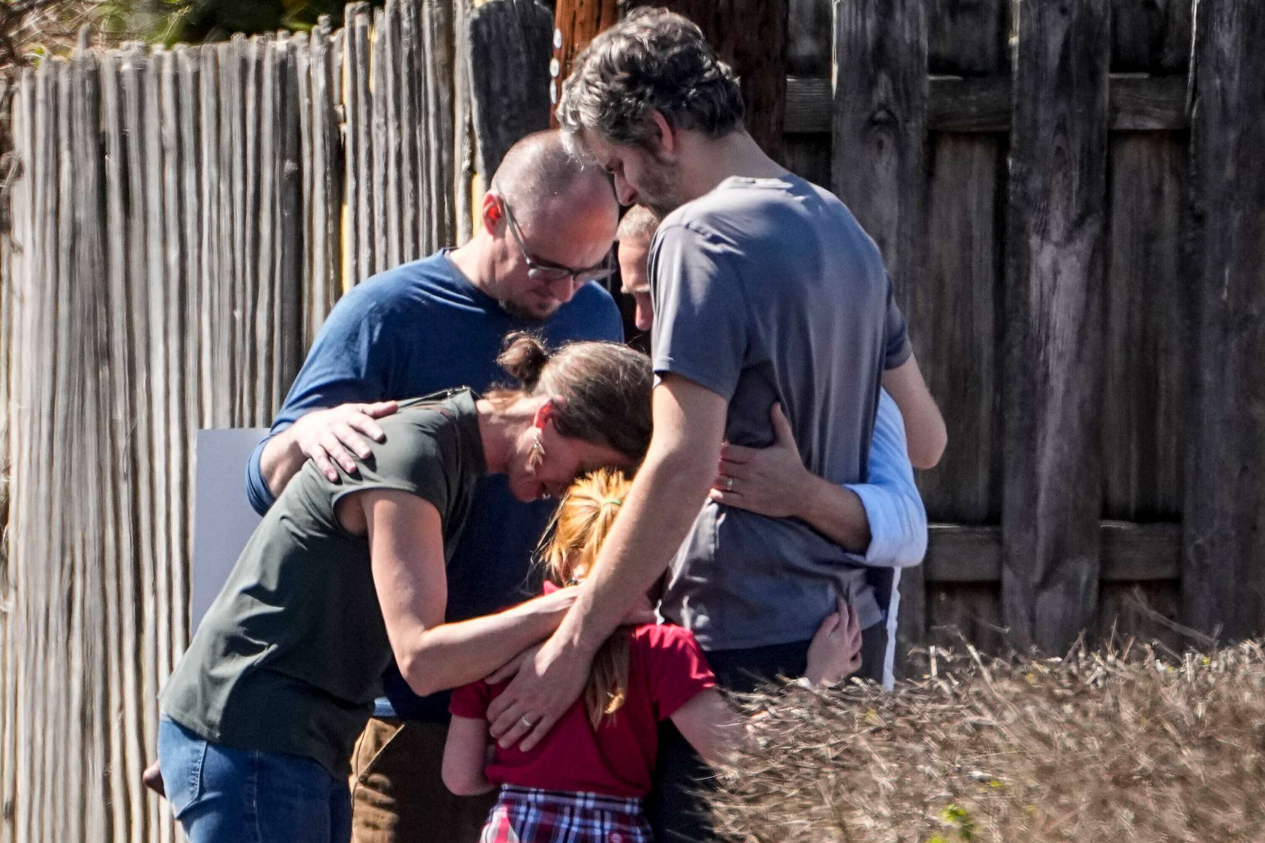 PHOTO: A group prays with a child outside the reunification center at the Woodmont Baptist church after a school shooting, Mar. 27, 2023, in Nashville, Tenn.