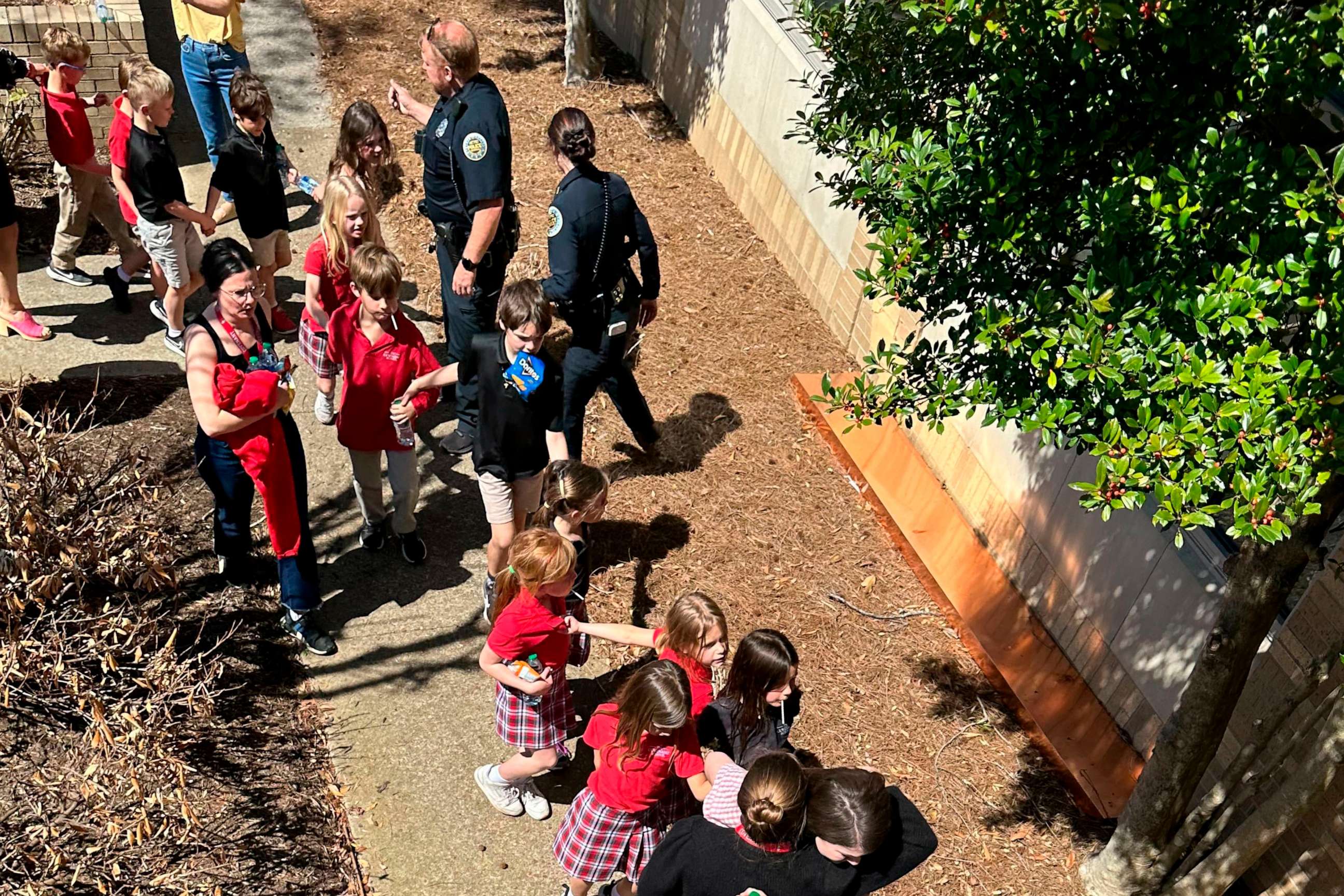 PHOTO: Children from The Covenant School, a private Christian school in Nashville, Tenn., hold hands as they are taken to a reunification site at the Woodmont Baptist Church after a shooting at their school, Mar. 27, 2023.
