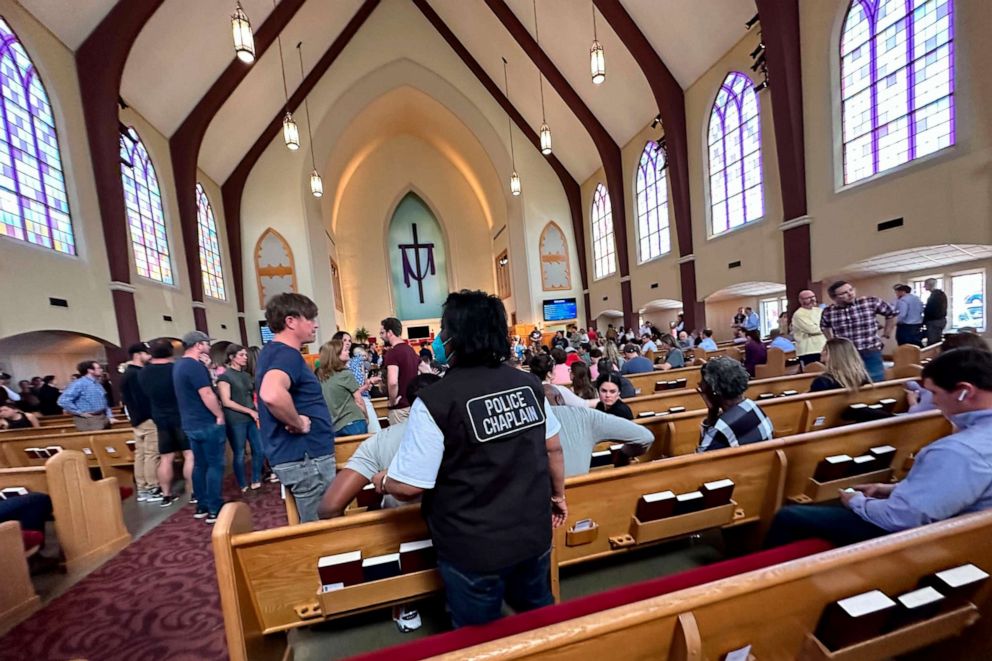PHOTO: A police chaplain stands by as children from The Covenant School, a private Christian school in Nashville, Tenn., are taken to a reunification site at the Woodmont Baptist Church after a shooting at their school, Mar. 27, 2023.