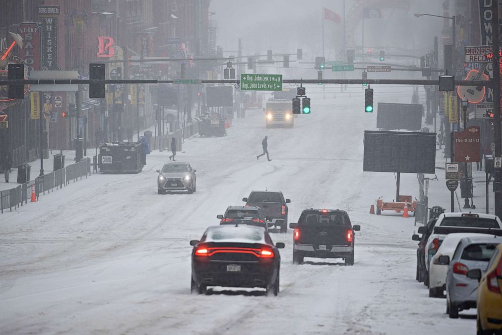 PHOTO: General view of Lower Broadway as vehicles and people traverse through snow and ice on Feb. 15, 2021, in Nashville, Tennessee.