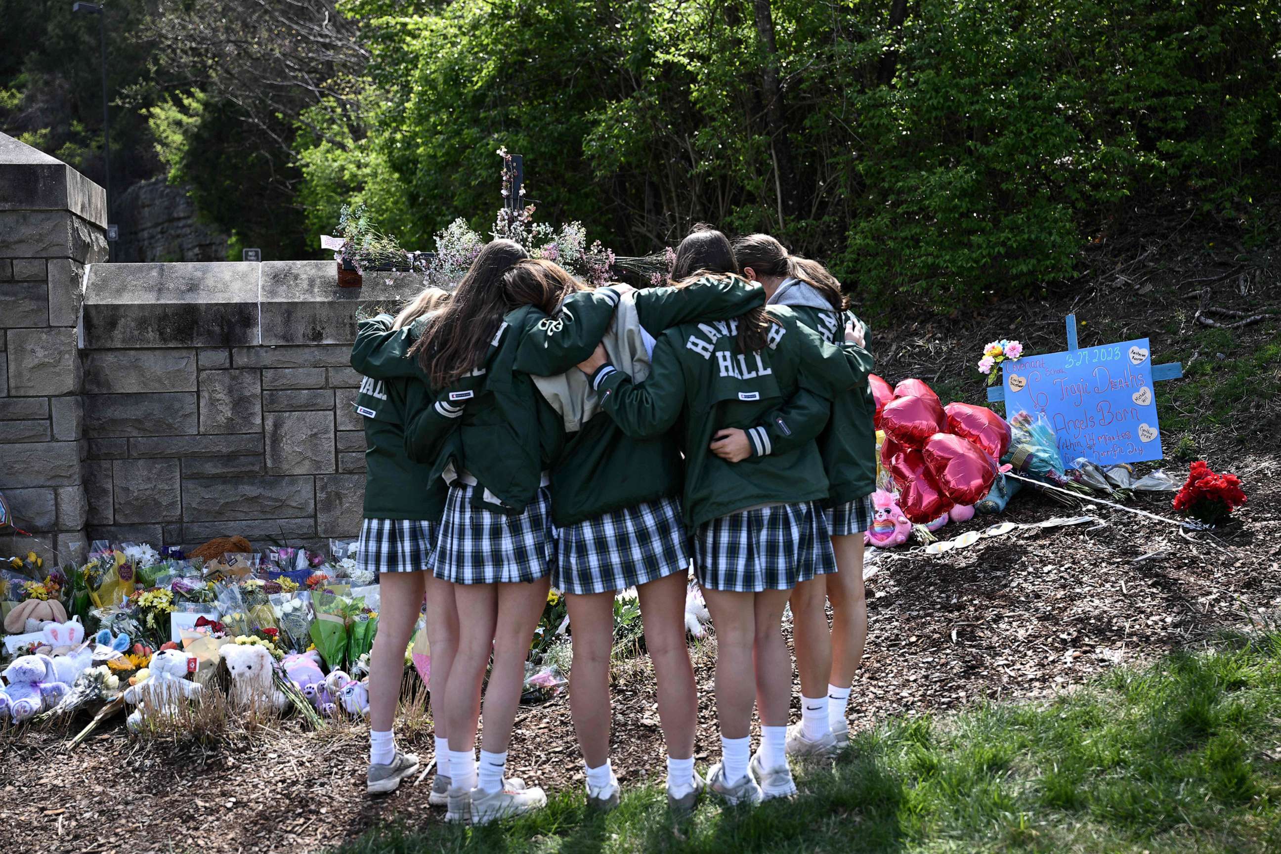 PHOTO: Girls embrace in front of a makeshift memorial for victims near the Covenant School building at the Covenant Presbyterian Church following a shooting that killed six, in Nashville, Tenn., March 28, 2023.