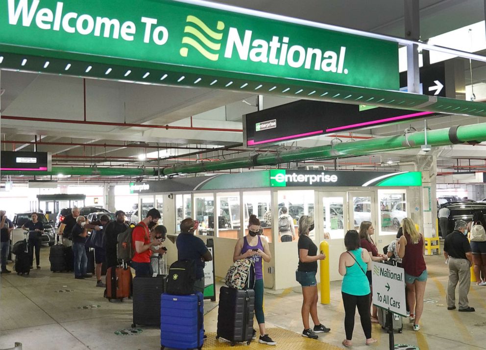 PHOTO: People wait in line at Enterprise car rental agency in the Miami International Airport on April 12, 2021 in Miami. Car rental agencies have limited supply of vehicles as people begin traveling again after being locked down during the pandemic.