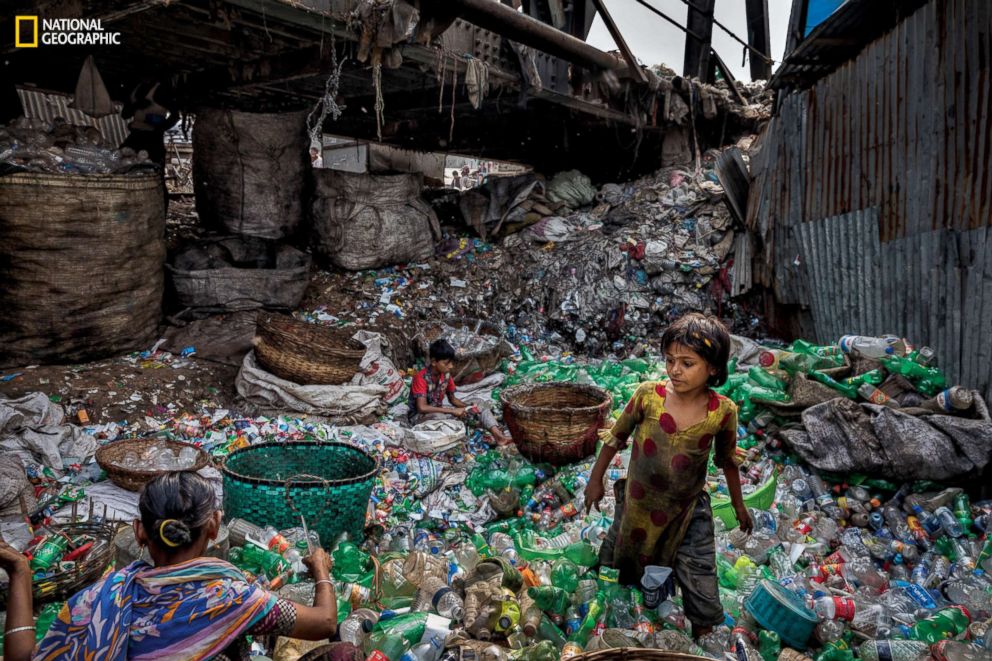 PHOTO: Under a bridge on a branch of the Buriganga River in Bangladesh, a family removes labels from plastic bottles, sorting green from clear ones to sell to a scrap dealer. Waste pickers here average around $100 a month.