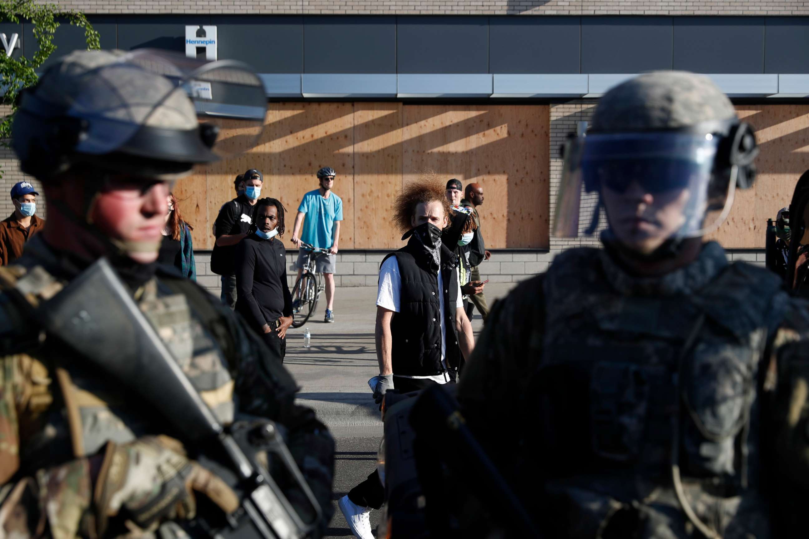 PHOTO: Demonstrators gathered near members of the Minnesota National Guard walk past onlookers Friday, May 29, 2020, in Minneapolis.