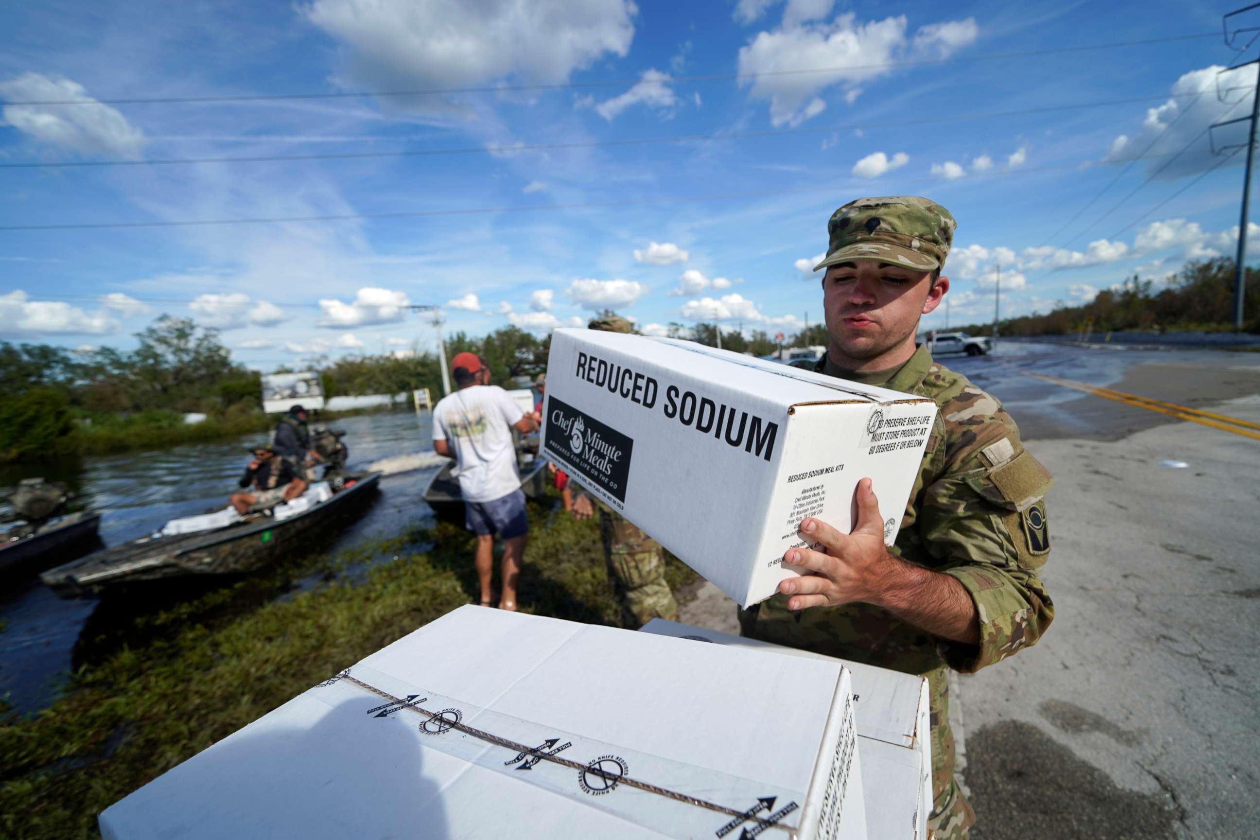 PHOTO: A member of the Florida National Guard helps stack emergency supplies that arrived by boat during flooding along the Peace River in the aftermath of Hurricane Ian in Arcadia, Fla., Oct. 3, 2022.