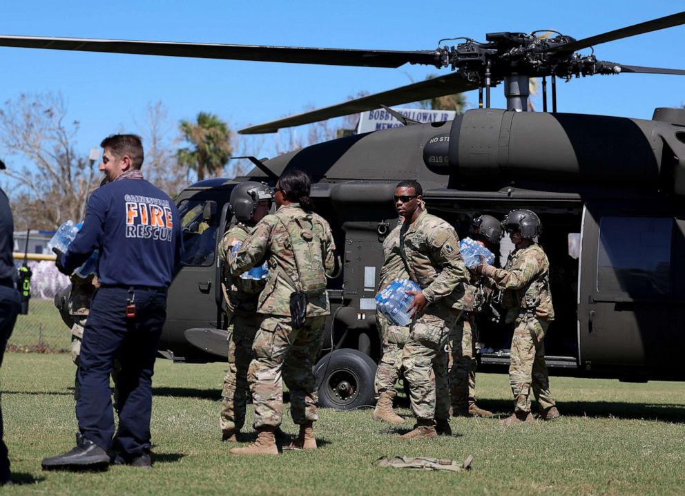 PHOTO: Florida Army National Guard members unload supplies from a helicopter on October 02, 2022 in Pine Island, Florida.