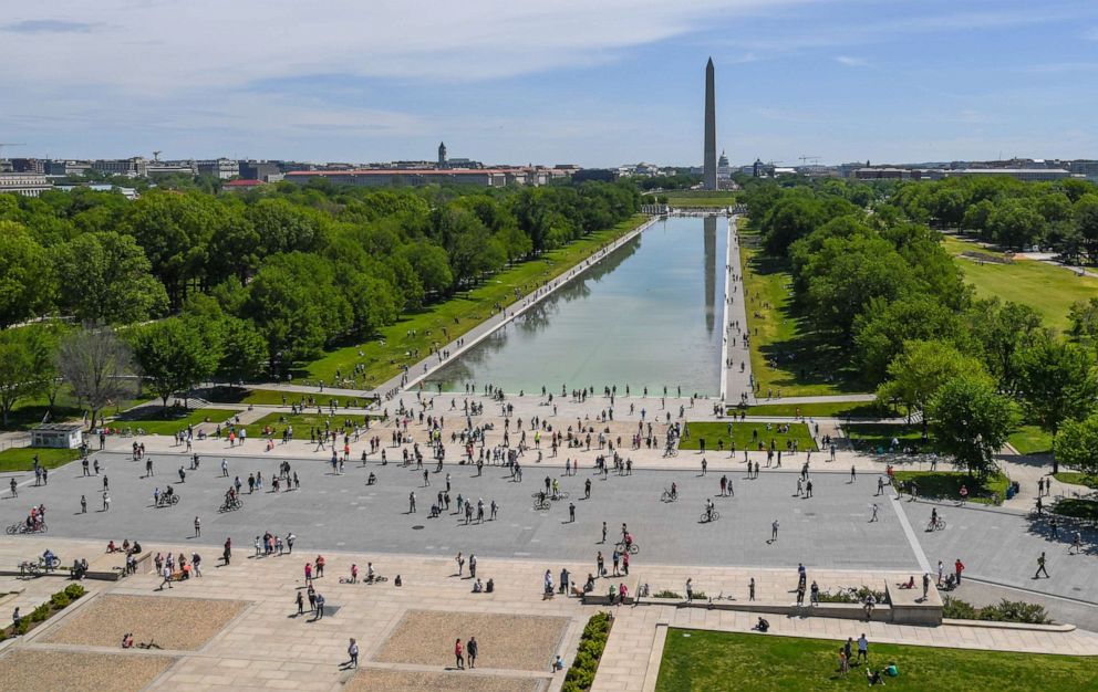 PHOTO: Visitors to the National Mall watch the Thunderbirds and Blue Angels during a flyover to support health care workers in Washington, May 2, 2020.
