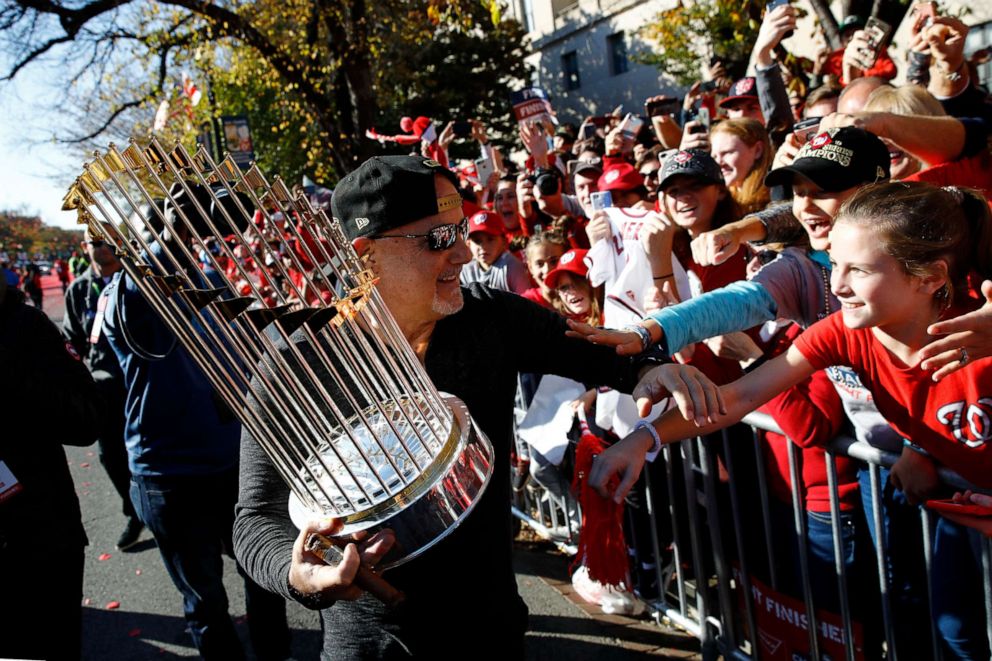 PHOTO: Washington Nationals general manager Mike Rizzo shows off the World Series trophy to cheering fans during a parade to celebrate the team's World Series baseball championship over the Houston Astros, Saturday, Nov. 2, 2019, in Washington.