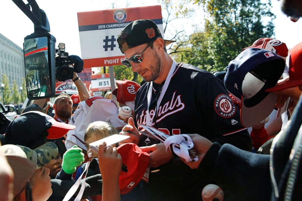 PHOTO: Washington Nationals starting pitcher Max Scherzer signs autographs for fans before a parade to celebrate the team's World Series baseball championship over the Houston Astros, Saturday, Nov. 2, 2019, in Washington.