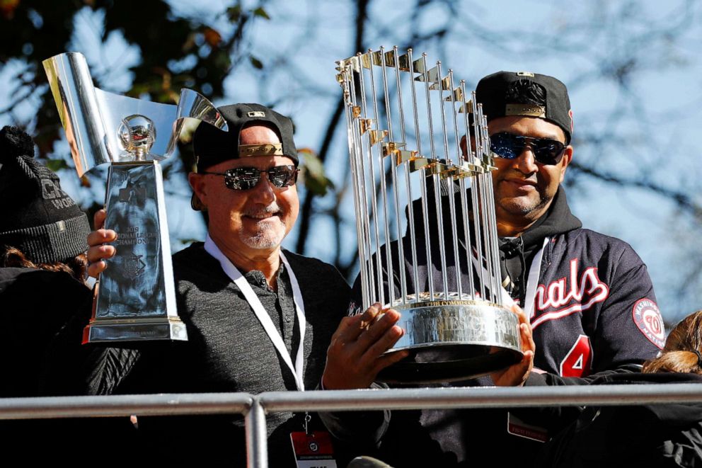 PHOTO: Washington Nationals general manager Mike Rizzo, left, and manager Dave Martinez hold up the NLCS trophy, left, and World Series trophy before a parade to celebrate the team's World Series baseball championship over the Houston Astros.
