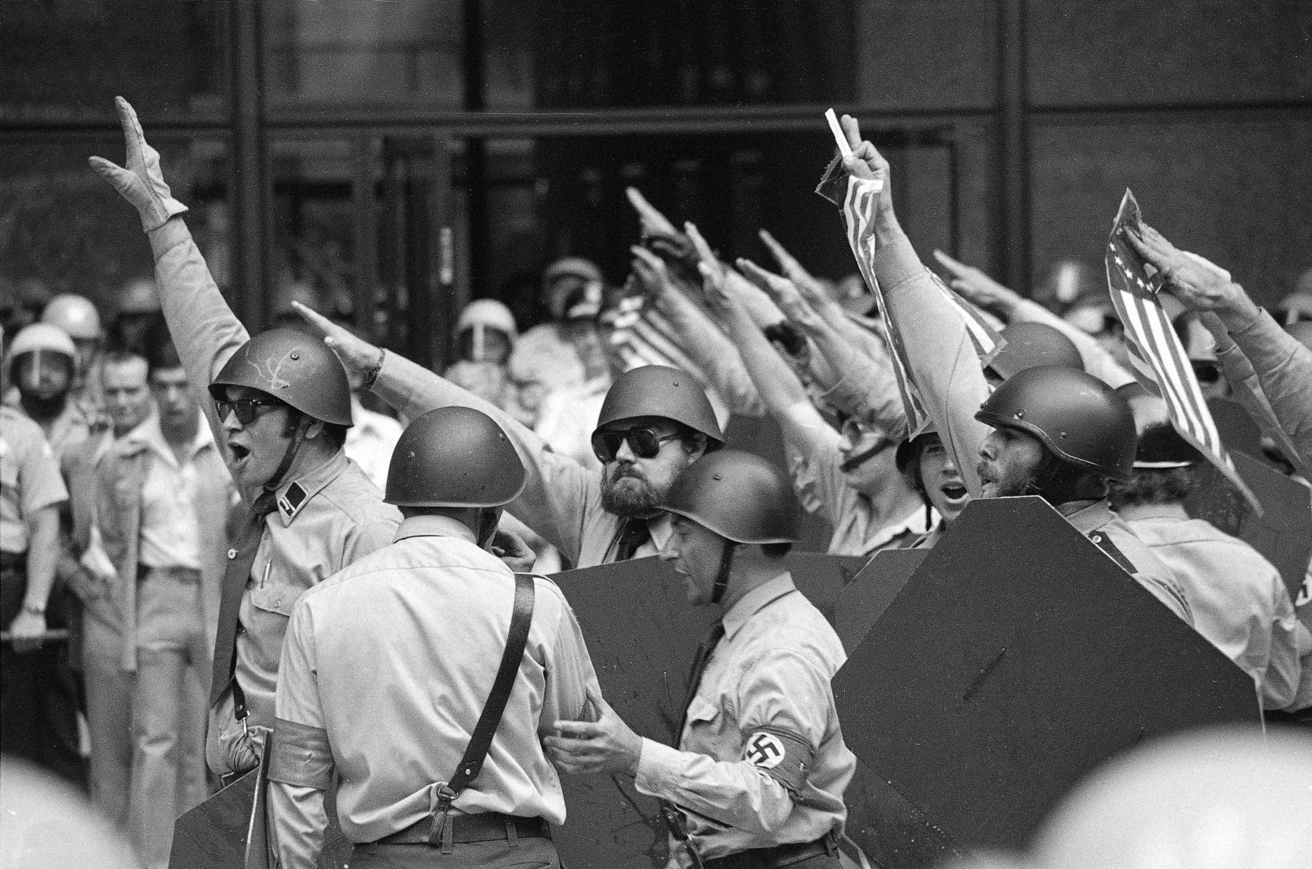 PHOTO: Nazi leader Frank Collin, pictured center, with the swastika armband leads helmeted members of the National Socialist Party of America give the Fascist salute during a rally in downtown Chicago, June 24, 1978.