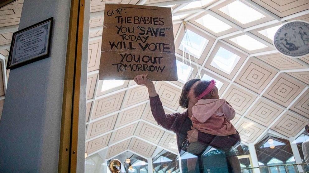 PHOTO: A demonstrator holds a sign and a baby outside a House Floor gallery window at the North Carolina State Legislature, May 3, 2023, after Republican state lawmakers announced their plan to limit abortion rights across the state.