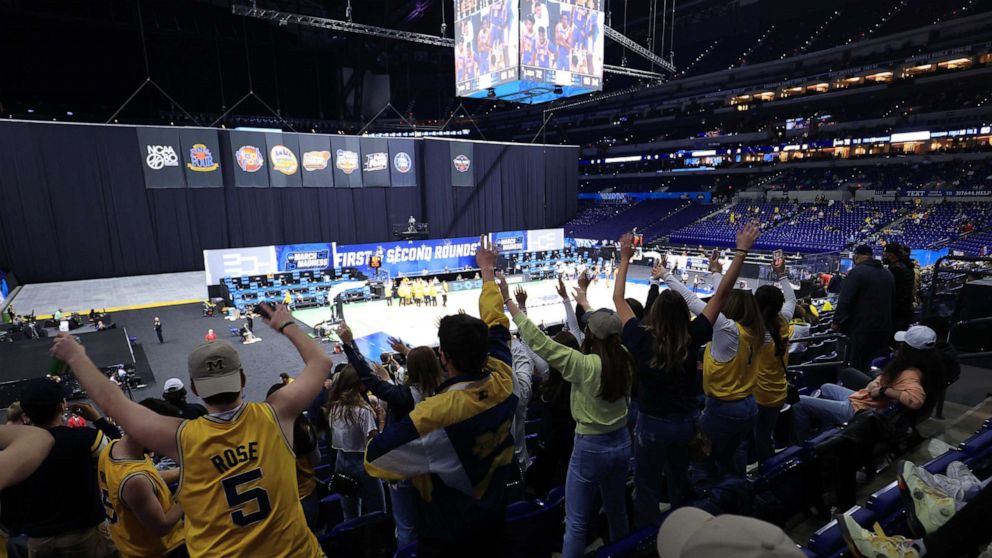 PHOTO: Michigan Wolverines fans cheer after the game in the second round of the 2021 NCAA Tournament against the Louisiana State Tigers at Lucas Oil Stadium, in Indianapolis, March 22, 2021.