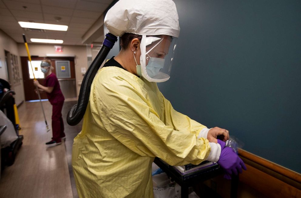 PHOTO: Nurse Nikole Hoggarth puts on her PPE before going to see a COVID-19 patient inside the emergency department at Jamestown Regional Medical Center on  Nov. 22, 2020, in Jamestown, N.D.
