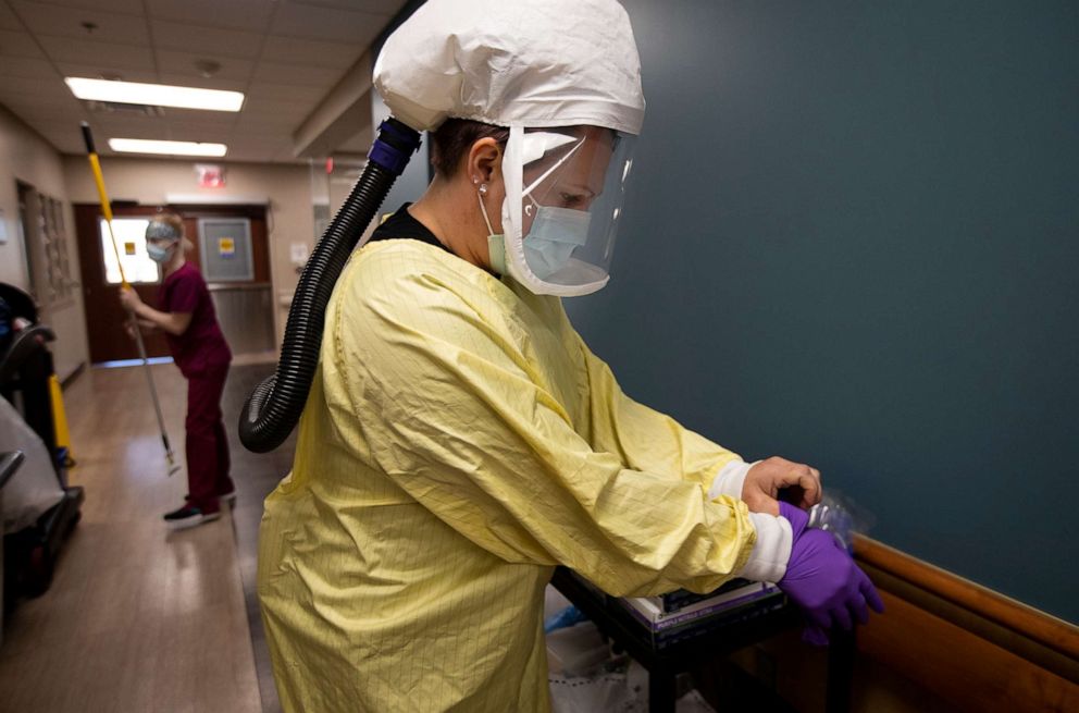 PHOTO: Nurse Nikole Hoggarth puts on her PPE before going to see a COVID-19 patient inside the emergency?department at Jamestown Regional Medical Center on  Nov. 22, 2020, in Jamestown, N.D.