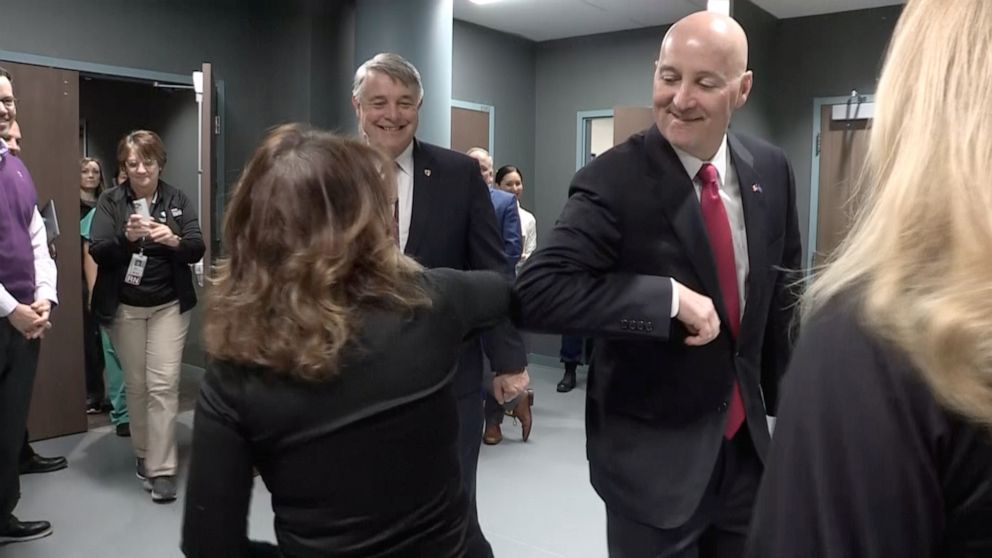 PHOTO: Nebraska Governor Pete Ricketts performs 'elbow bump' with Jeri Seratti-Goldman, an evacuee form coronavirus-hit Diamond Princess cruise ship,  after she left quarantine at the Nebraska Medical Center in Omaha, Neb., March 2, 2020.