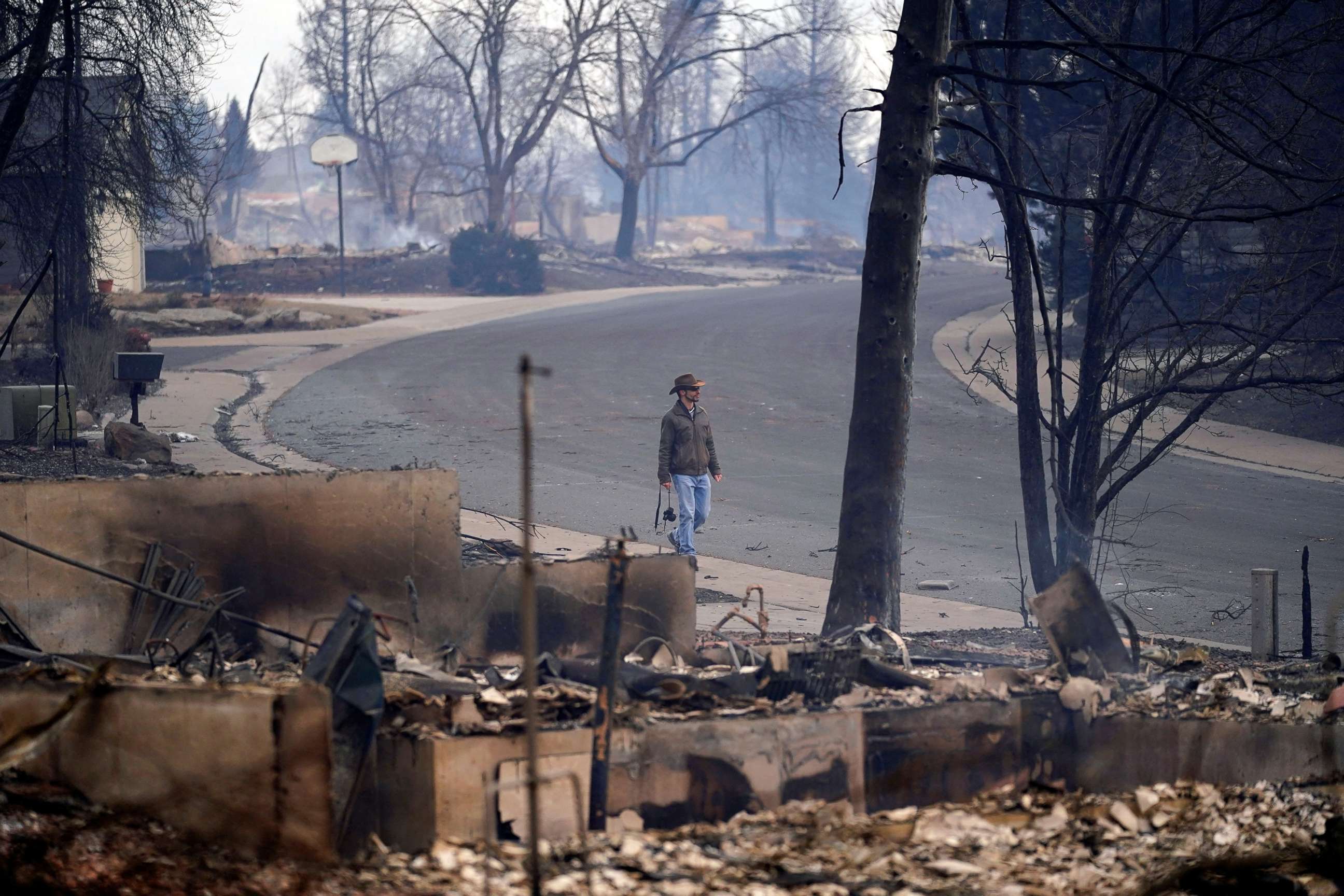 PHOTO: A man walks through a destroyed neighborhood after the wildfire in Louisville, Colo., Dec. 31, 2021. 