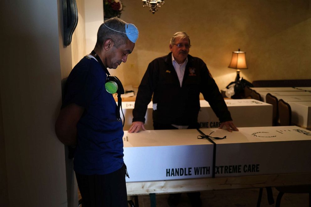 PHOTO: From left, Omar Rodriguez and Ray Neufeld pause while organizing bodies in the Gerard Neufeld funeral home in Queens, April 22, 2020 in New York City.