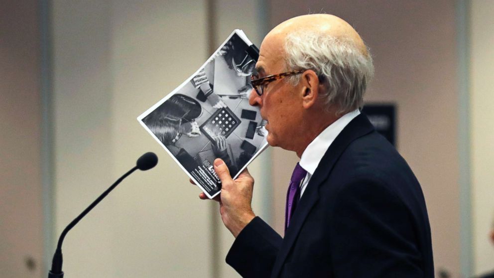 Attorney Steven M. Gordon, who represents lottery winner "Jane Doe", holds up an annual report from the New Hampshire Lottery during a hearing in the Jane Doe v. NH Lottery Commission case at Hillsborough Superior Court in Nashua, N.H., Feb. 13, 2018.