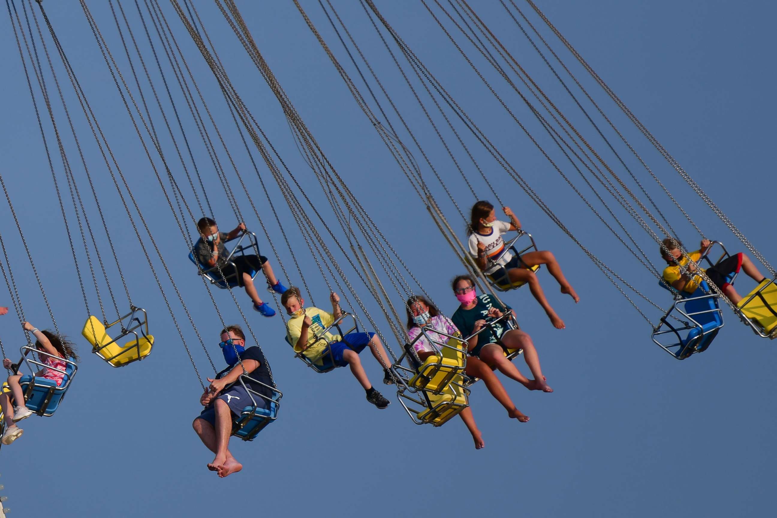 PHOTO: People wearing masks ride attractions at an amusement pier on July 3, 2020, in Wildwood, N.J.