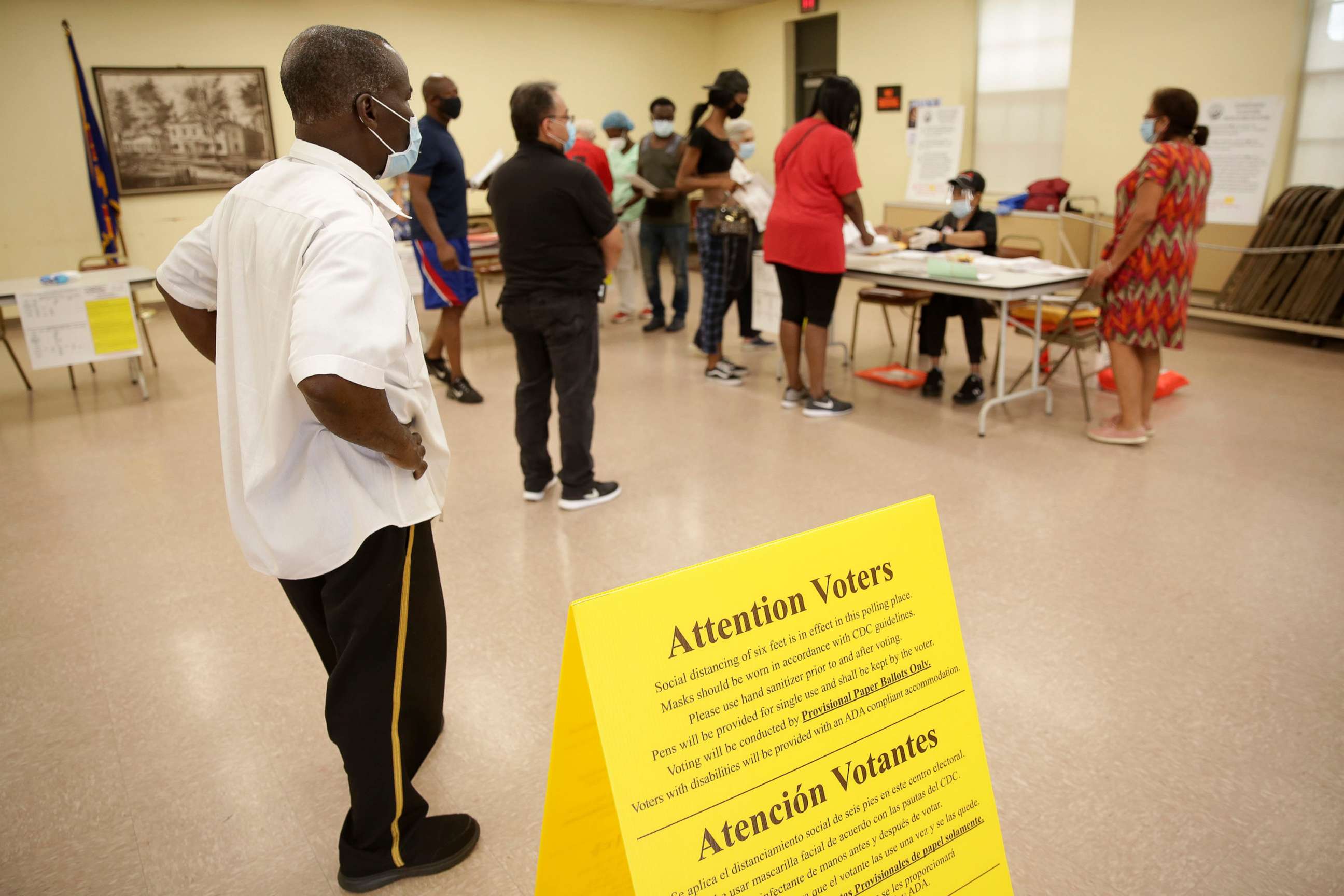 PHOTO: Voters wait in line to receive provisional ballots at a polling site in Hackensack, N.J., July 7, 2020.