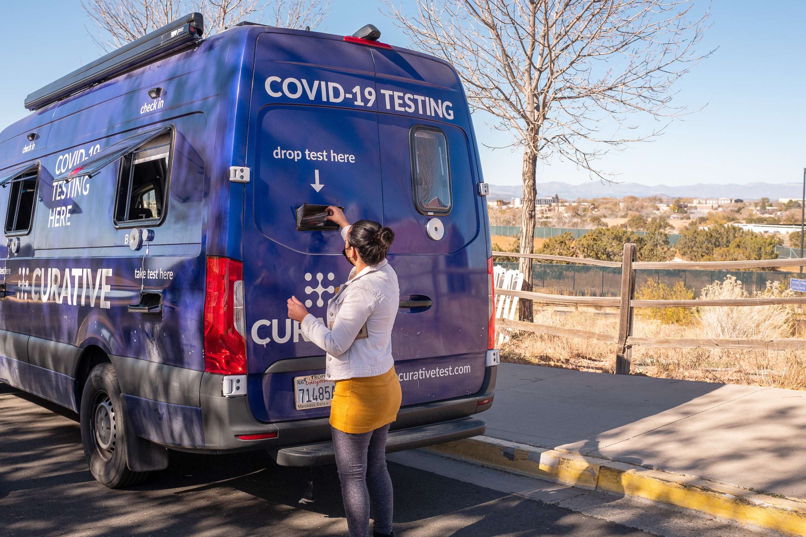 PHOTO: A patient places their Covid-19 test into a drop box at a Curative mobile testing site in Santa Fe, N.M., Nov. 11, 2021.