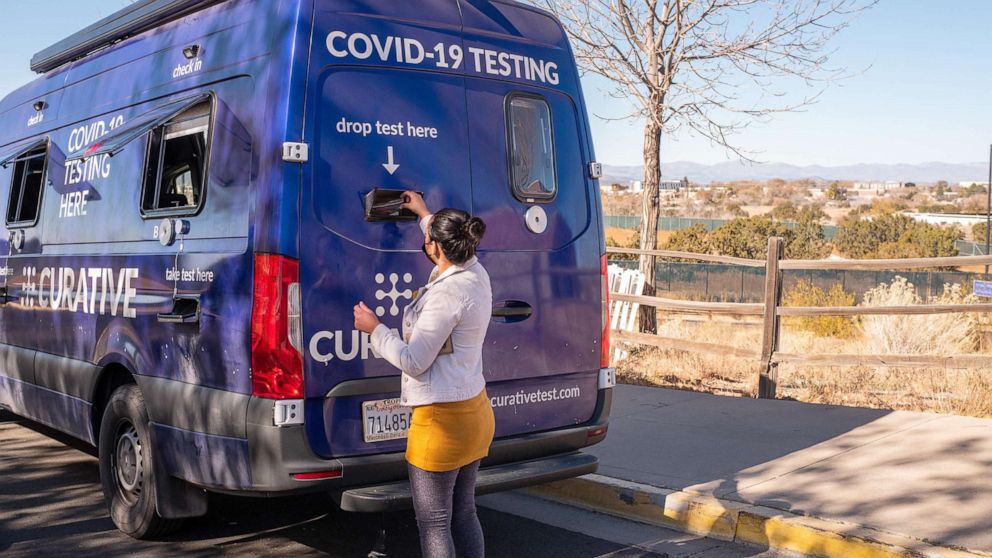PHOTO: A patient places their Covid-19 test into a drop box at a Curative mobile testing site in Santa Fe, N.M., Nov. 11, 2021.