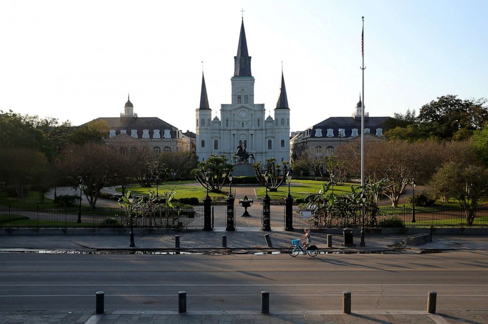 PHOTO: A woman rides a bike past Jackson Square in the amid the outbreak of the coronavirus disease (COVID-19), in New Orleans, Louisiana, U.S. March 25, 2020.