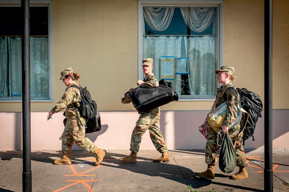 PHOTO: National Guard members walk down Rampart Street in New Orleans, Louisiana, on March 26, 2020.