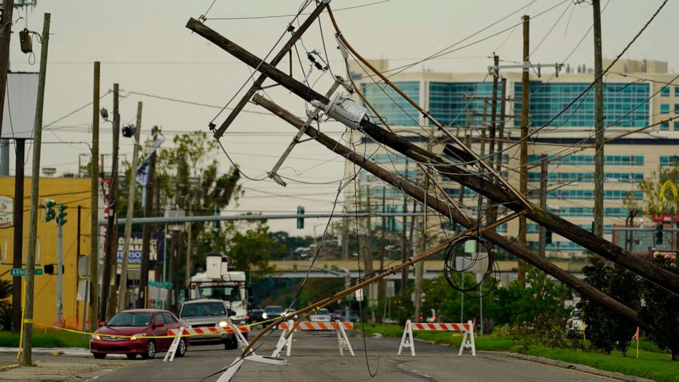 PHOTO: Vehicles are diverted around utility poles damaged by the effects of Hurricane Ida, Tuesday, Aug. 31, 2021, in New Orleans. New Orleans is without power, which may last for several weeks. 