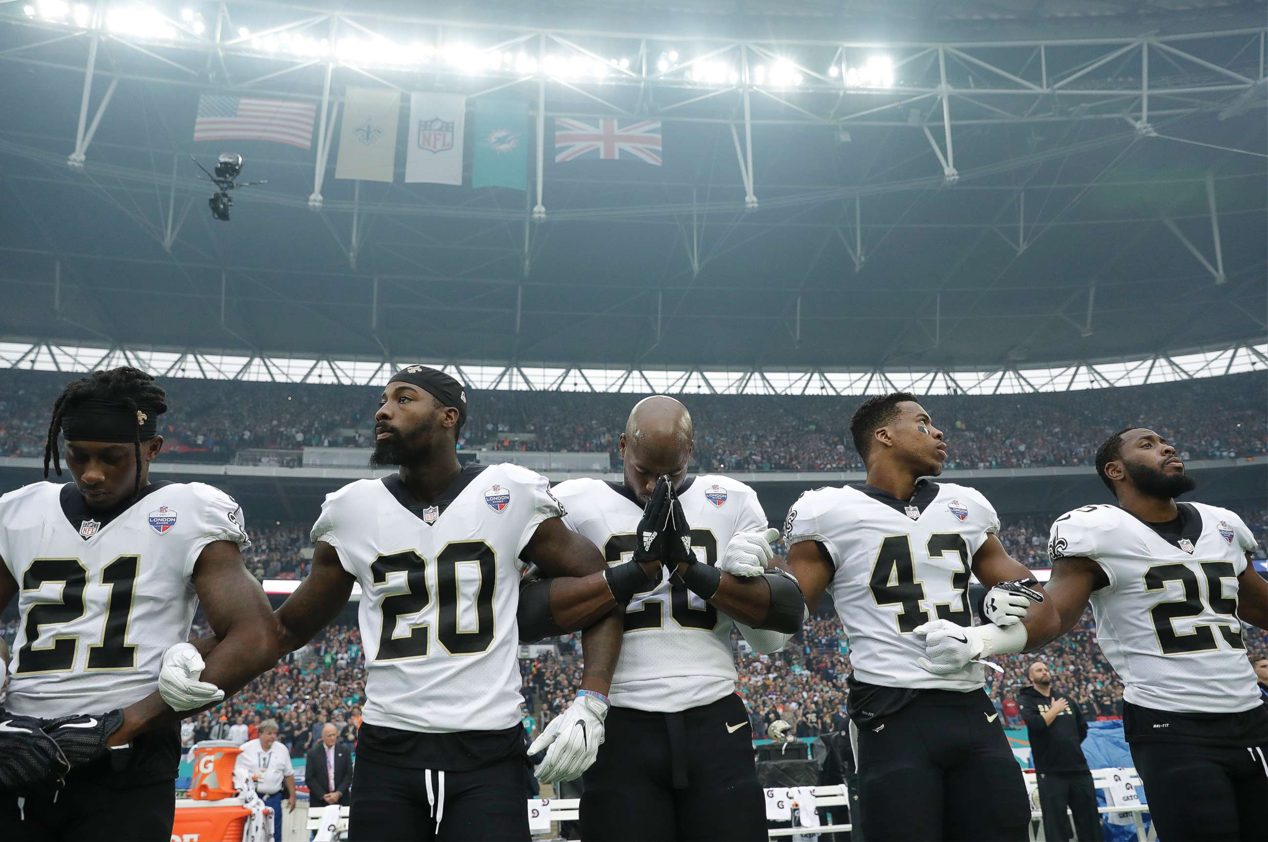 PHOTO: New Orleans Saints running back Adrian Peterson, center, prays as he and teammates lock arms as they stand for the U.S. national anthem ahead of an NFL football game against Miami Dolphins at Wembley Stadium in London, Oct. 1, 2017. 