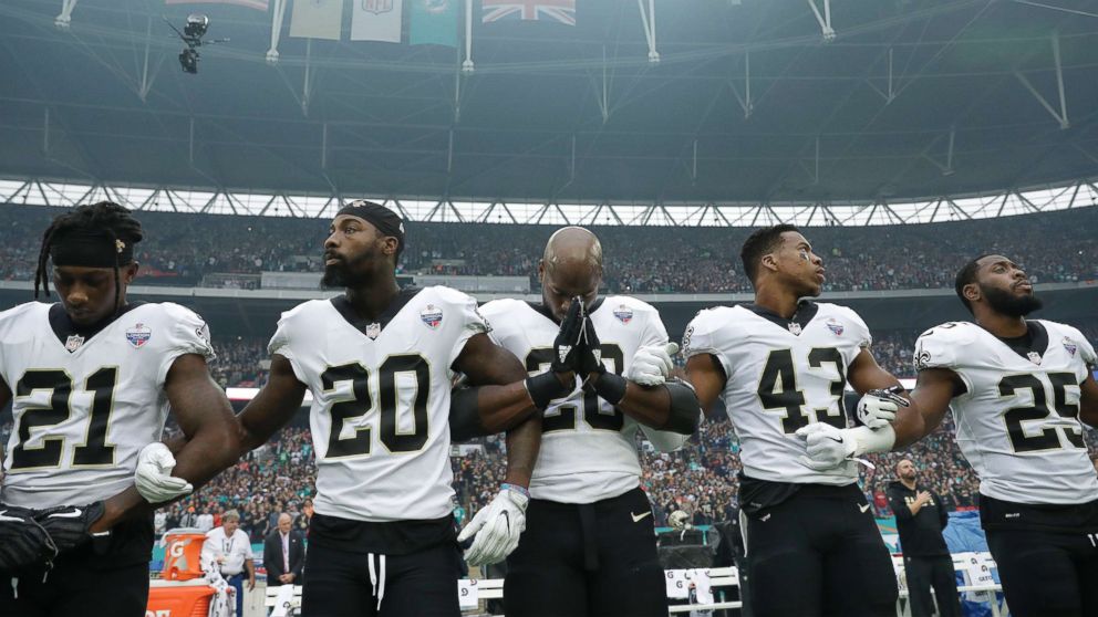 PHOTO: New Orleans Saints running back Adrian Peterson, center, prays as he and teammates lock arms as they stand for the U.S. national anthem ahead of an NFL football game against Miami Dolphins at Wembley Stadium in London, Oct. 1, 2017. 