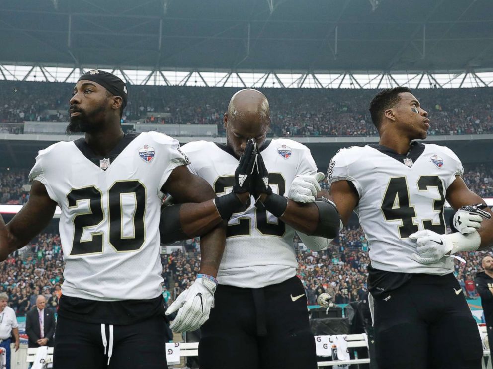 PHOTO: New Orleans Saints running back Adrian Peterson, center, prays as he and teammates lock arms as they stand for the U.S. national anthem ahead of an NFL football game against Miami Dolphins at Wembley Stadium in London, Oct. 1, 2017.