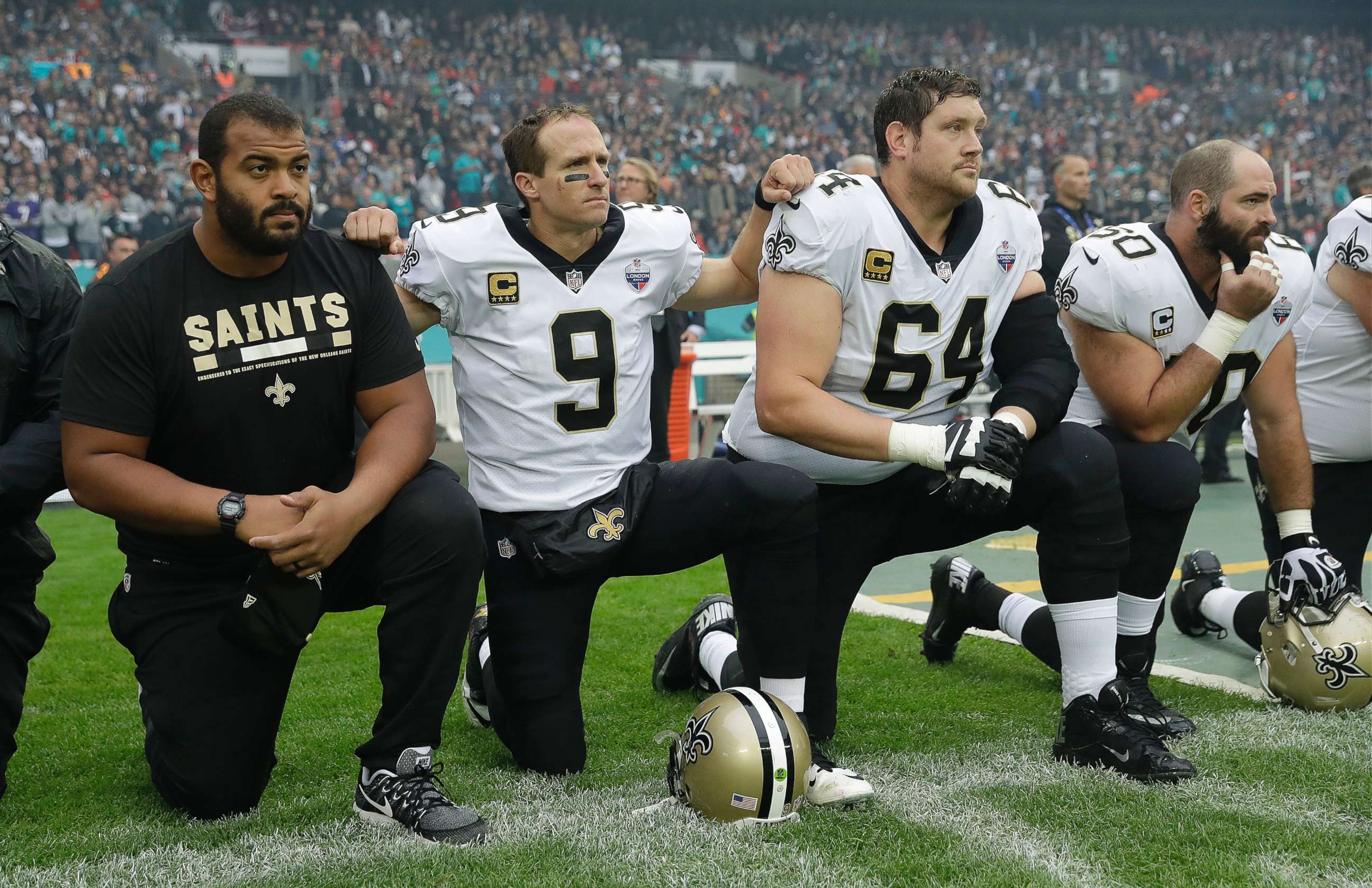 PHOTO: New Orleans Saints quarterback Drew Brees (9) kneels down with teammates before the U.S. national anthem was played ahead of an NFL football game against Miami Dolphins at Wembley Stadium in London, Oct. 1, 2017. 