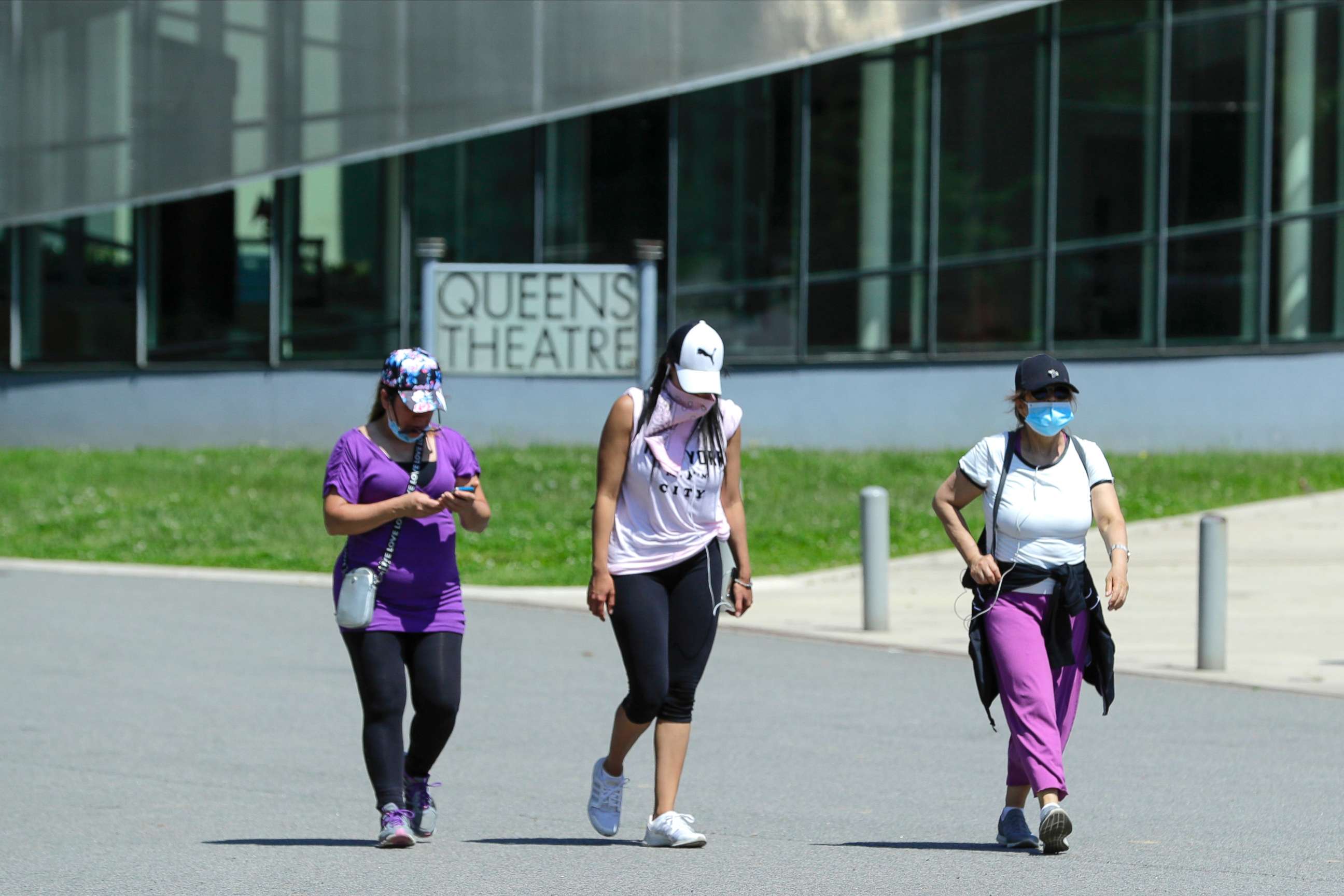 PHOTO: Women wear protective masks during the coronavirus pandemic as they pass the Queens Theatre, Tuesday, May 26, 2020, in the Queens borough of New York. (AP Photo/Frank Franklin II)