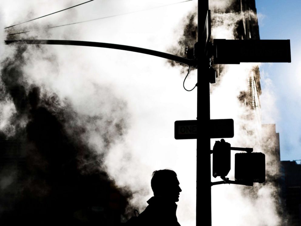 PHOTO: A pedestrian walks past a cloud of steam coming from a manhole on a brisk morning in New York City, Nov. 10, 2017.
