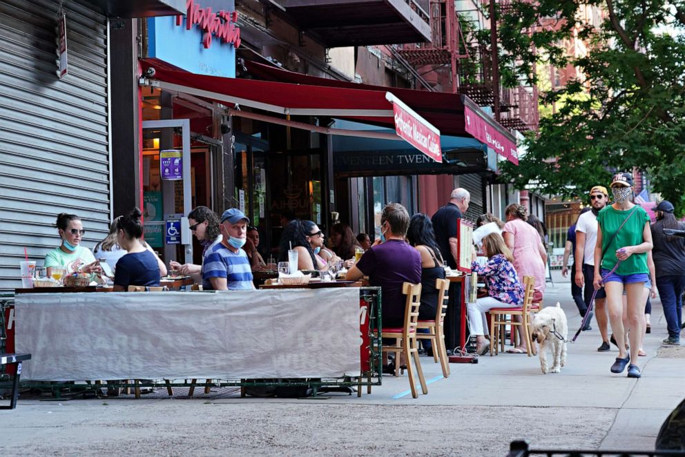 PHOTO: Customers are served at outside tables as the city moves into Phase 2 of re-opening following restrictions imposed to curb the coronavirus pandemic, June 24, 2020 in New York City.