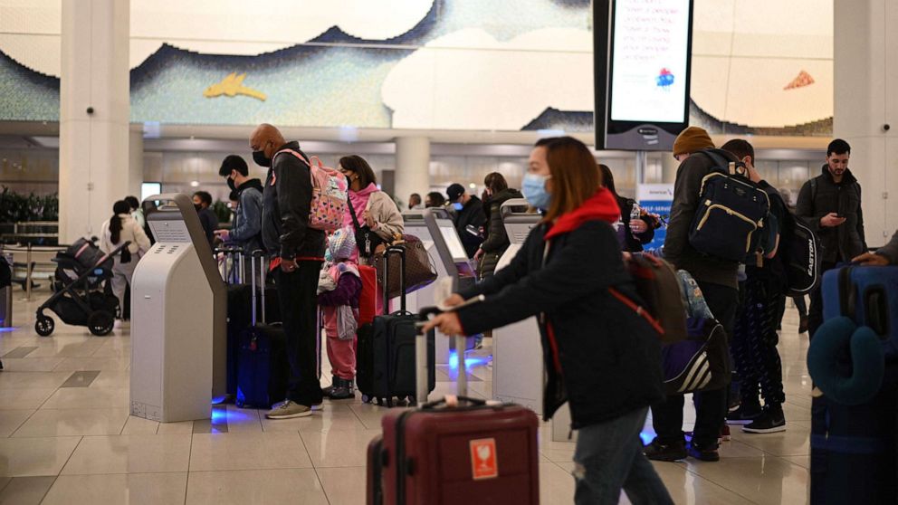 PHOTO: Travelers wear masks at LaGuardia International Airport, Nov. 30, 2021, in New York, as concern grows worldwide over Omicron, the newest COVID-19 variant.