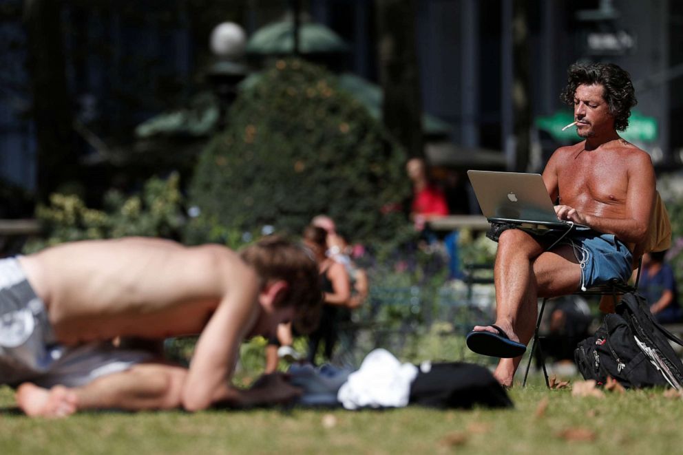 PHOTO: A man works on a computer in the sun at Bryant Park in New York, October 2, 2019.