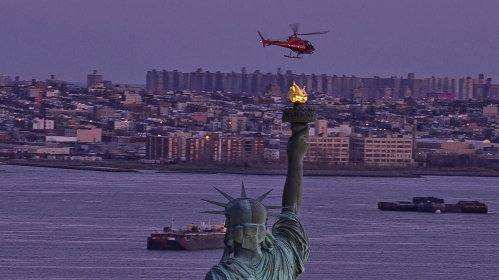 PHOTO: A chartered helicopter that later crashed into New York's East River flies past the Statue of Liberty in New York, March 11, 2018.